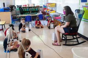 IMG_0265 teacher in rocking chair with students on floor