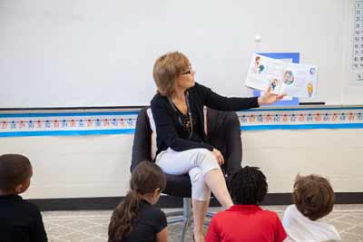 Rebecca Ginnetti reading a book to students